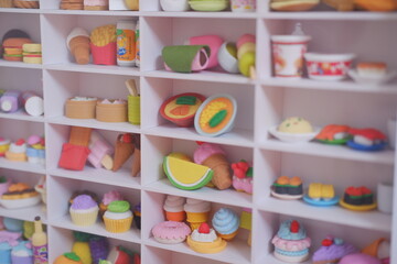 Colorful eraser cupcakes and other sweets on a shelf in a children's room