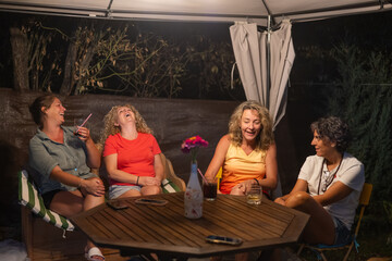 Four Adult Women Hugging And Smiling, Enjoying A Cheerful And Fun Gathering Or Conversation In A Moment Of Friendship And Joy.