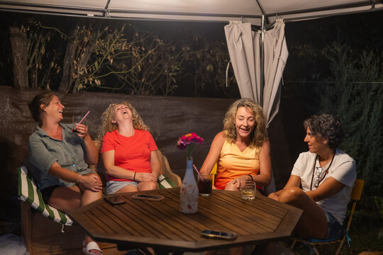 Four Adult Women Hugging And Smiling, Enjoying A Cheerful And Fun Gathering Or Conversation In A Moment Of Friendship And Joy.