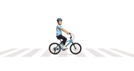 Obraz premium Happy boy riding a bicycle at a pedestrian crossing