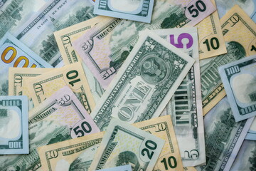 Big amount of US dollar bills in different nominations on table. Many dollar banknotes under natural light