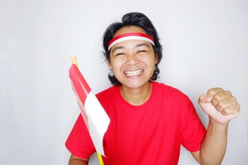 Portrait of an Indonesian man with long hair with a headband and red shirt celebrating Indonesian Independence Day with high nationalism on an isolated white background