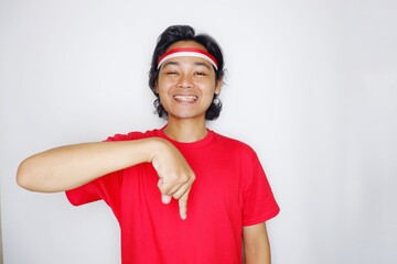 Portrait of an Indonesian man with long hair with a headband and red shirt celebrating Indonesian Independence Day with high nationalism on an isolated white background