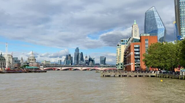 Pan across the River Thames at Blackfriars Bridge to the busy Southbank and iconic Oxo tower in the heart of London.