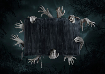 Mummy's hands wrapped in a bandage rises through the wooden boards. Background with copy space. The...
