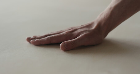 closeup man hand touches plywood to check surface