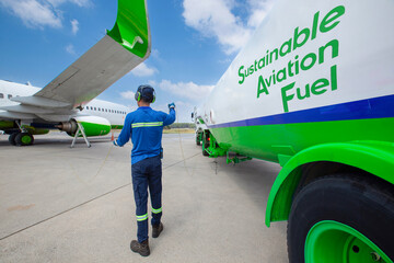 Sustainable Aviation Fuel (SAF) Technician refueling private jet with SAF at the airport.