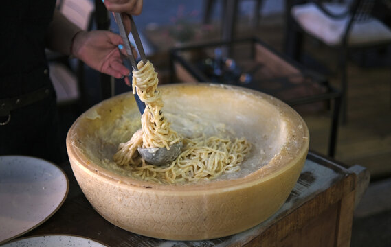 Preparing spaghetti in a wheel of Grana Padano cheese