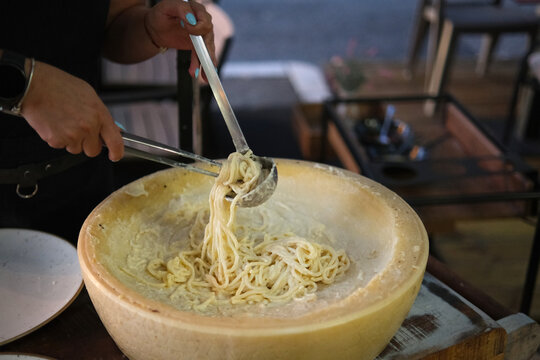 Preparing spaghetti in a wheel of Grana Padano cheese