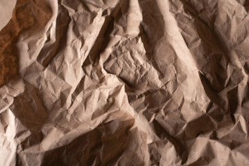 A detailed close-up showcasing the complex texture and shadows of crumpled brown paper.