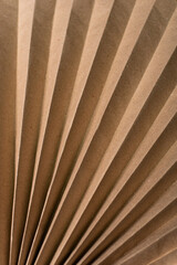 Vertical background of corrugated brown paper. Folded paper from fallen leaves