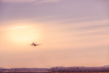 plane taking off, rising towards the sunrise sun. Holidays and travel