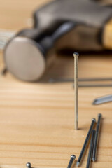 nails with small caps and an iron hammer on boards