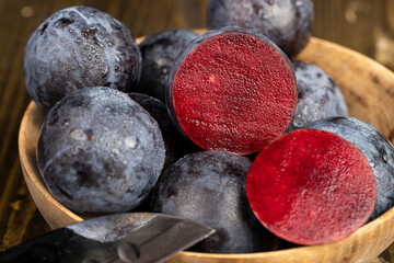 cut purple plums on the table during cooking