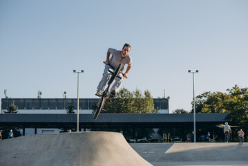Daring mid adult male cyclist with ponytail spending time by improving hobby skills outdoors