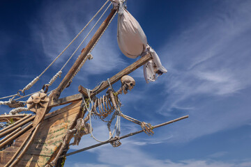 Torn sails on the masts of a pirate ship against the sky