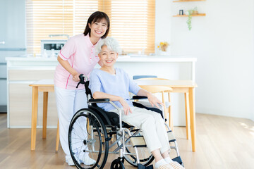 車椅子に乗った女性をサポートする介護士