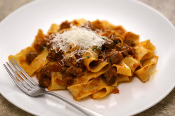 Homemade pappardelle pasta with lamb ragu sauce. Italian cuisine.