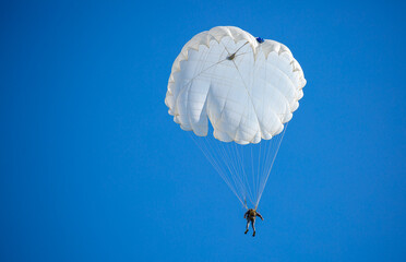 Skydiving. Flying parachutists against the background of the blue sky and mountains. Extreme sport...