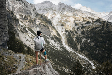 A hiker girl with a backpack in the mountains of Albania. Trekking in the Prokletie Mountains.