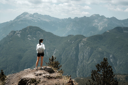 A hiker girl with a backpack in the mountains of Albania. Trekking in the Prokletie Mountains.