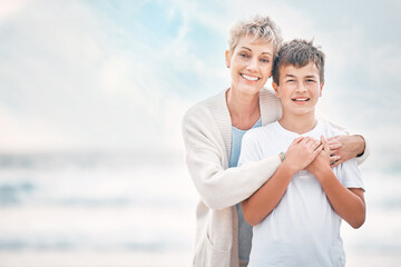 Obraz premium Hug, portrait and granny with grandson on beach together for holiday, travel or vacation. Love, mockup space or smile with senior woman and boy child embracing outdoor for summer bonding or wellness