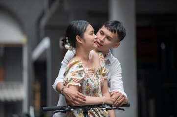 Fototapeta premium Young Asian Couple enjoying a bicycle in the city, man and woman relaxing together outside