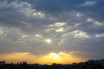 Sunset over city. Evening city landscape. Sunset over multi-story buildings. Cityline with colorful sky. Residential area of the city in evening. Cityscape with summer sunset. Town, metropolis