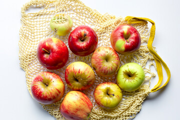 Bag of s with reds and greens on it's mesh. eco reusable food concept. a bag of fruit with s and pears in white on a . a bag of fruit with a red and white lifestyle and wicker.