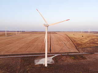 Windfarm against a blue sky. The white blades of the wind turbine close up. Renewable energy source. European Green Deal