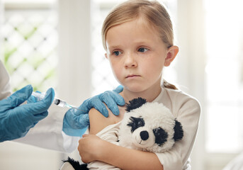 Little girl, needle and injection with doctor for vaccine, medical treatment or cure on bed at...
