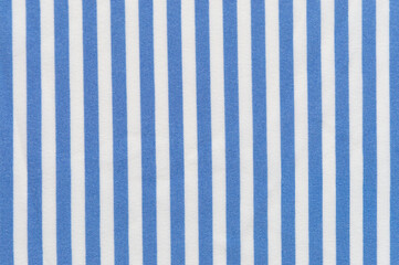 A close-up of a sky blue and white vertical striped linen shirt. Textured, striped background image.