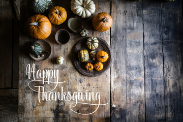 Happy Thanksgiving text with pumpkins and leaves over dark weathered wood background