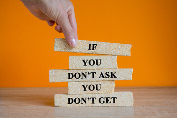 Brick blocks with words If you don't ask, you don't get on the wooden table. Beautiful orange...