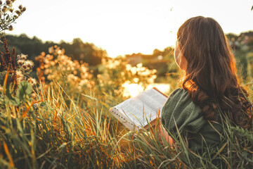 Girl with an open Bible in her hands, summer mood
