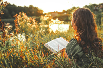 Girl with an open Bible in her hands, summer mood