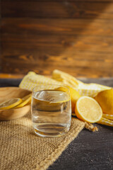 Cool freshly made lemonade in glass on wooden table. Space for text
