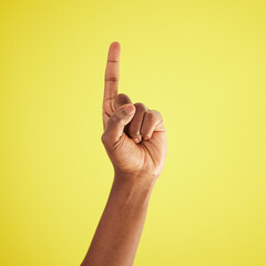 Model, hand and pointing up in studio with mockup for question, choice or vote on yellow background. Product placement, finger and deal announcement or information with mock up space for notification