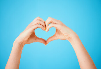 Person, heart hands and emoji with love for care, like or support in studio on a blue background....