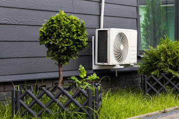 external air conditioner unit mounted on the wall of the house. outdoor unit of air conditioner. home cooling system. home air conditioner