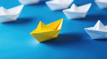 Naklejka premium Yellow paper boat stands out from white paper boats on a blue background.
