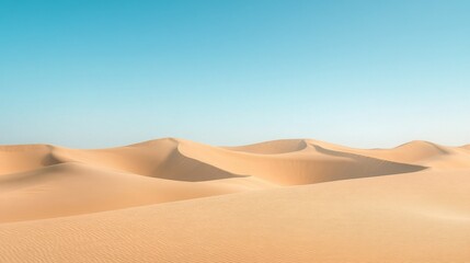 Desert landscape view with rolling sand dunes and a clear blue sky, emphasizing the vastness. 