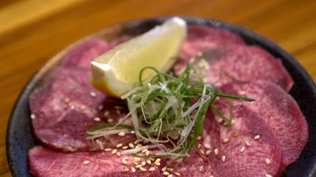 Slice of beef ox tongue gyutan lemon Japanese yakiniku bbq food 4k