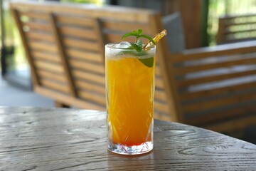 A glass of orange juice on the table. Mint leaves and dried orange as garnish. Healthy drink with...