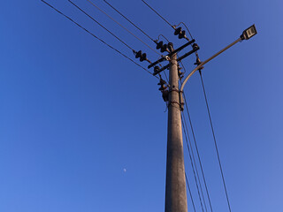 Power electric pole with line wire for residential buildings with blue sky background