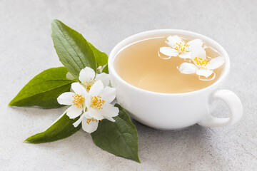 Hot Tea with jasmine in a white cup. Light gray background. Close up
