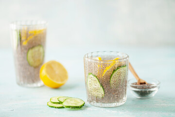 Chia seed water with lemon and cucumber slices in drinking gasses on wooden table. Drink for a healthy diet