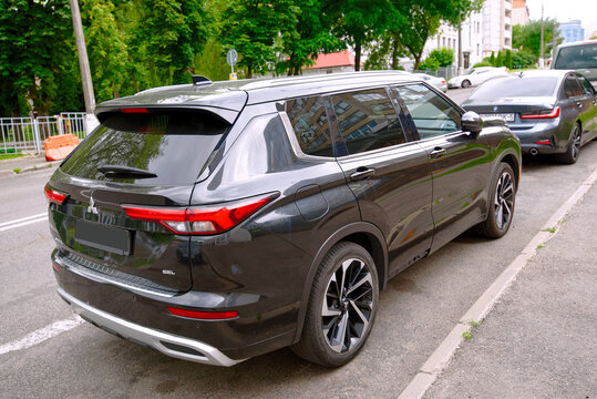 Minsk, Belarus. Jun 23, 2024. Mitsubishi Outlander black SUV rear view. Mitsubishi Outlander parked in parking lot along roadside.