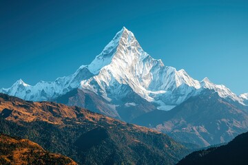 Fototapeta premium Majestic Snow-Capped Mountain Peak with Blue Sky and Forest Foothills