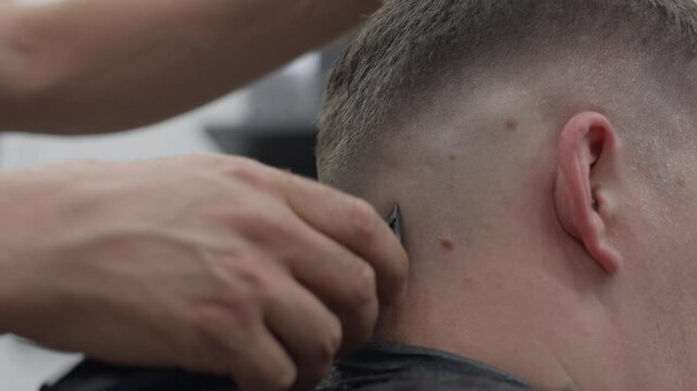 Close-up of Barber Giving Fade Haircut with Electric Clipper to Male Caucasian Client. Concept of Grooming, Precision, Personal Care, Technique, Salon, Craftsmanship, barber shop, shaver, Hairstyling